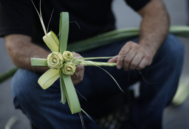 Joseph Heinrich makes crosses from palm fronds during a Stop the Violence Rally in Las Vegas Friday, Sept. 13, 2013. (John Locher/Las Vegas Review-Journal)