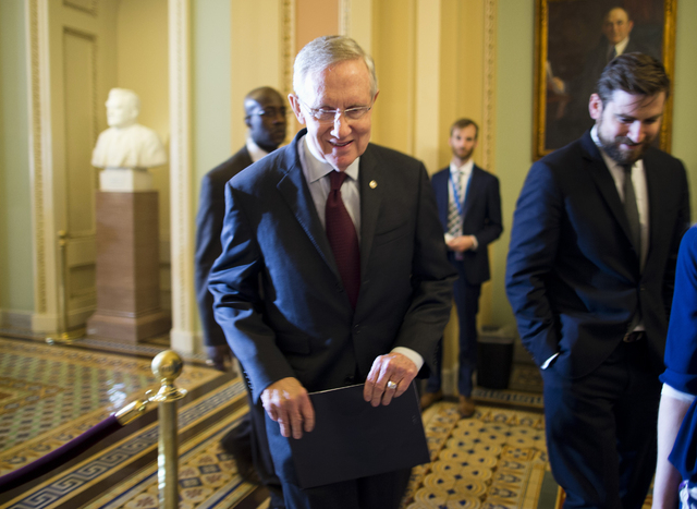 Senate Majority Leader Harry Reid, D-Nev., walks to a Senate Democratic caucus to discuss the ongoing budget fight Monday on Capitol Hill in Washington. (AP Photo/ Evan Vucci)