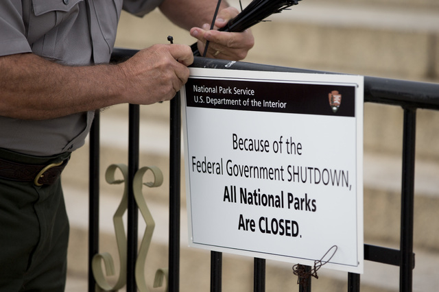 A National Park Service employee posts a sign on a barricade closing access to the Lincoln Memorial Tuesday in Washington. Congress plunged the nation into a partial government shutdown Tuesday as ...