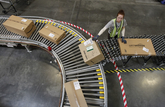 In this Nov. 11, 2010 file photo, Katherine Braun sorts packages toward the right shipping area at an Amazon.com fulfillment center in Goodyear, Ariz. Amazon.com said Tuesday, Oct. 1, 2013, it is  ...