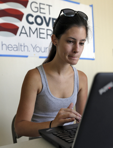 Ashley Hentze, left, of Lakeland, Fla., signs up for the Affordable Care Act with Enroll America, a private, non-profit organization running a grassroots campaign to encourage people to sign up fo ...