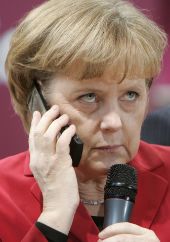 German Chancellor Angela Merkel poses with a cell phone on March 5 at the booth of Sony Ericsson during her opening walk at the CeBIT in Hanover, northern Germany. (AP Photo/Joerg Sarbach)