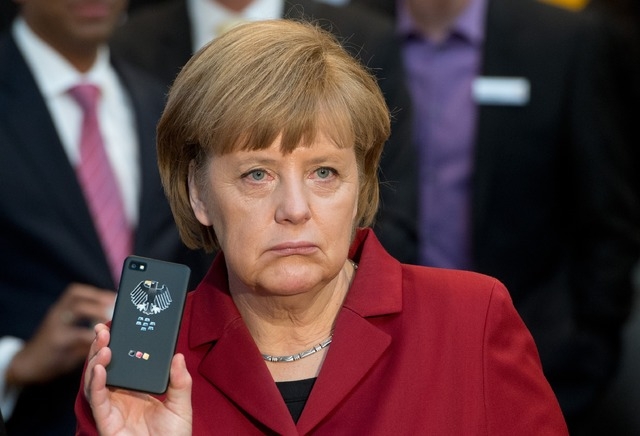 German Chancellor Angela Merkel presents a tap-proof mobile phone of Blackberry at a booth of Secusmart on March 5 during the opening round tour of the world's largest computer expo CeBIT in Hanno ...