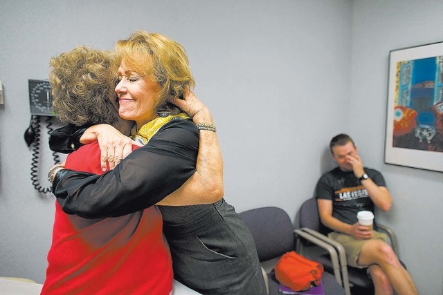 Oncologist Heather Allen hugs patient Mary Ann Hoban at Comprehensive Cancer Centers of Nevada while Hoban's grandson, Joe Hoban, looks on Friday, Sept. 20, 2013. Mary Ann Hoban, 83, began taking  ...