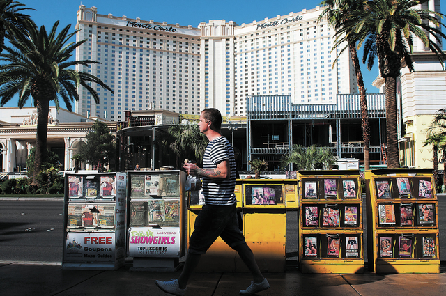 A man walks by news racks along Las Vegas Boulevard in Las Vegas, Tuesday, Oct. 22, 2013. An ordinance is being considered by Clark County that would ban all news racks on the Strip. (Erik Verduzc ...