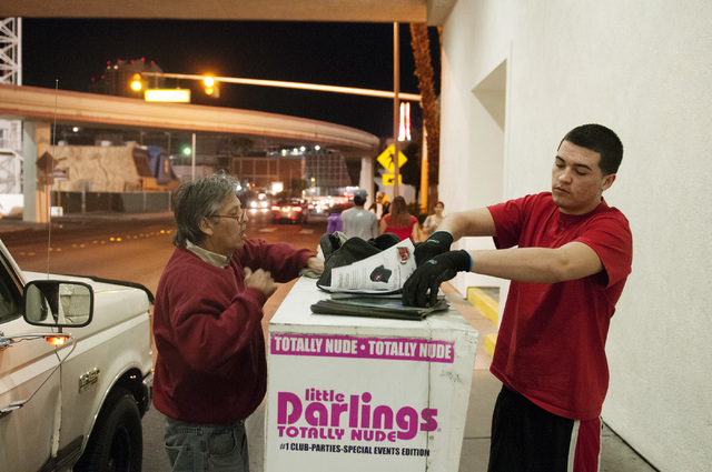 Eddie Munoz, left, owner of Strip Advertising, refills news racks with his son Brandon near Circus Circus Hotel in Las Vegas, Thursday, Oct. 24, 2013. An ordinance is being considered by Clark Cou ...