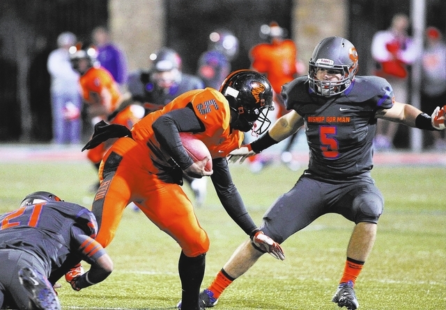 Bishop Gorman's Kenyan Coker (21) and Ryan Garrett (5) converge on Booker T. Washington quarterback Treon Harris (5) at Fertitta Field in Las Vegas on Oct. 4, 2013.(Jason Bean/Las Vegas Review-Jou ...