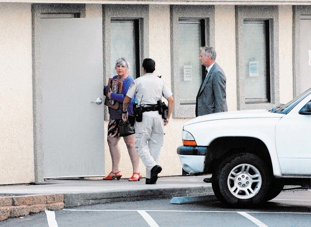 Shirley Matson with NCSO deputy and FBI agent entering the Assor's office (Horace Langford Jr. / Pahrump Valley Times)