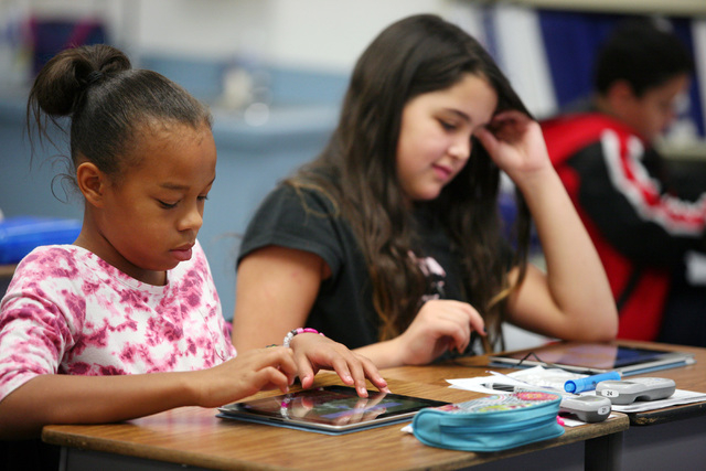 Students Ani Riley, left, and Aidan Patterson (both CQ) work with a web-based phonic program called Lexia on iPads in Steve Armitage’s 5th grade class at Hancock Elementary School Friday, O ...