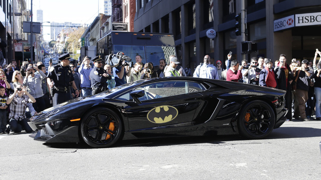 The crowd cheers as Miles Scott, 5, dressed as Batkid, as he rides inside the Batmobile in San Francisco on Friday, Nov. 15, 2013. (AP Photo/Bay Area News Group, Gary Reyes)
