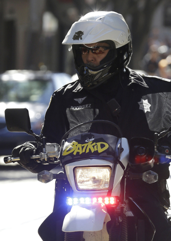 A San Francisco Police Officer with a Batkid sign on his bike waits for the arrival of Miles Scott, dressed as Batkid, in San Francisco, Friday, Nov. 15, 2013. (AP Photo/Jeff Chiu)