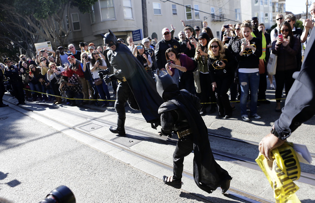 Miles Scott, 5, dressed as Batkid, follows Batman as they go to rescue a damsel in distress in San Francisco, Friday, Nov. 15, 2013. (AP Photo/Bay Area News Group, Gary Reyes)