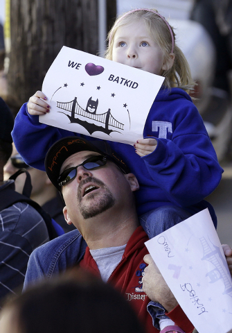 Daniel Fry holds up his daughter Kayla, 5, as they wait for Miles Scott, dressed as Batkid, in San Francisco, Friday, Nov. 15, 2013.  (AP Photo/Jeff Chiu)