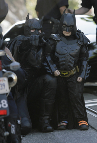 Batman assists Miles Scott, 5, dressed as Batkid, as he prepares to save a damsel in distress in San Francisco on Friday, Nov. 15, 2013. (AP Photo/Bay Area News Group, Gary Reyes)