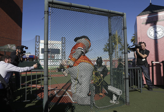 Miles Scott, as Batkid, center right, rescues San Francisco Giants mascot after being kidnapped by the Penguin at AT&T Park in San Francisco, Friday, Nov. 15, 2013. (AP Photo/Jeff Chiu)