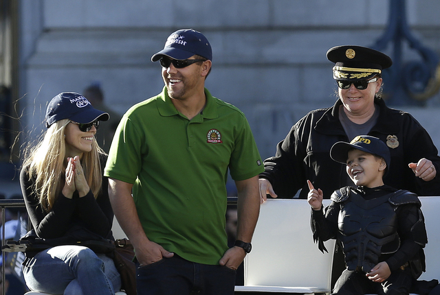 Miles Scott, dressed as Batkid, bottom right, smiles at a rally outside of City Hall with his parents, Natalie and Nick, and San Francisco Police Chief Joanne Hayes-White in San Francisco, Friday, ...