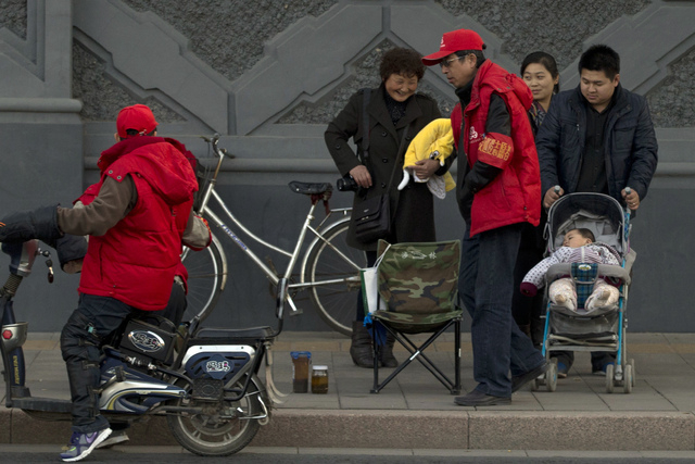 A child rest in a stroller on the streets of Beijing, China, on Tuesday. China announced a loosening of family planning rules that limit many couples to a single child in the first substantial cha ...