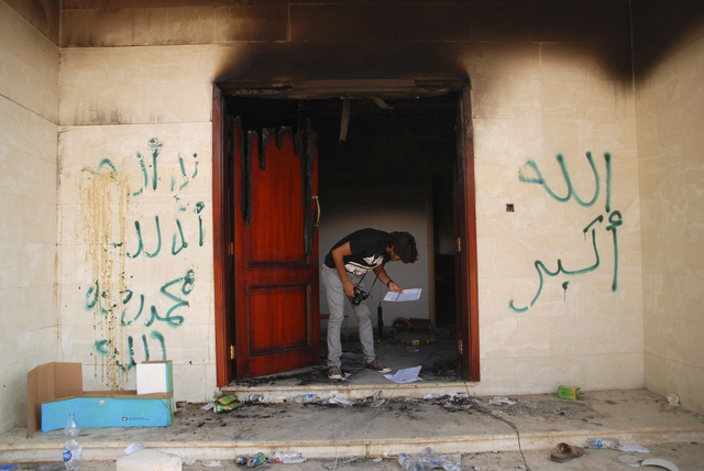 A man looks at documents at the U.S. consulate in Benghazi, Libya, after an attack on Sept. 12, 2012, that killed four Americans, including Ambassador Chris Stevens. (AP Photo/Ibrahim Alaguri, File)