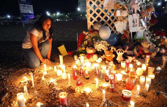 13-year-old Irene Beltran kneels by a memorial at the corner of Blue Diamond Road and Cimarron Road in Las Vegas Thursday, Nov. 14, 2013. The memorial is for 14-year-old Helen Liu who was killed w ...