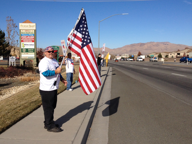 Mark Ransom, of Fernley, waves to traffic with about two dozen protestors in Carson City on Thursday, Nov. 14, 2013, seeking the repeal, or at least delay, of the new health care law. (Sean Whaley ...