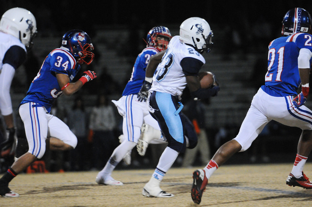 Canyon Springs running back Zaviontay Stevenson (23) breaks free from Liberty defenders during the Sunrise Region semifinal game at Liberty High School in Henderson, Friday, Nov. 15, 2013. Canyon ...