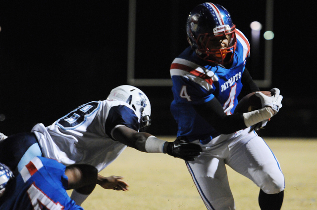 Liberty running back Ethan Tullagi (4) breaks free from a Canyon Springs defender during the Sunrise Region semifinal game at home in Henderson, Friday, Nov. 15, 2013. The Liberty Patriots were do ...