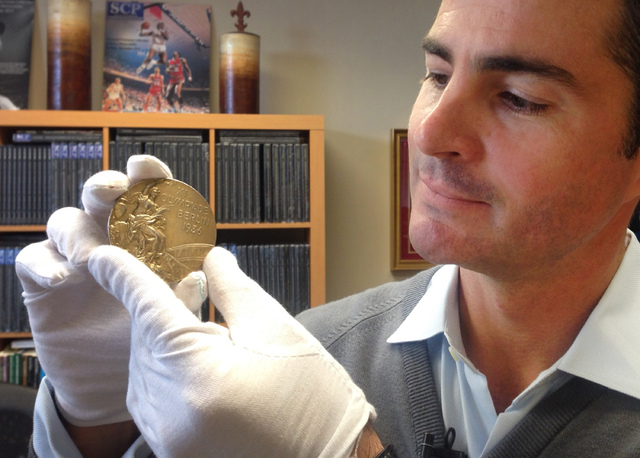 In this Nov. 19, 2013 photo, Dan Imler of SCP Auctions shows Jessie Owens gold medal from the 1936 Olympics at the SCP Auctions in Laguna Nigel, Calif. One of the four Olympic gold medals won by t ...
