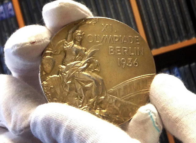 This Nov. 19, 2013 photo shows track and field star Jesse Owens' gold medal is displayed from his 1936 Olympics win at the SCP Auctions in Laguna Nigel, Calif. One of the four Olympic gold medals  ...