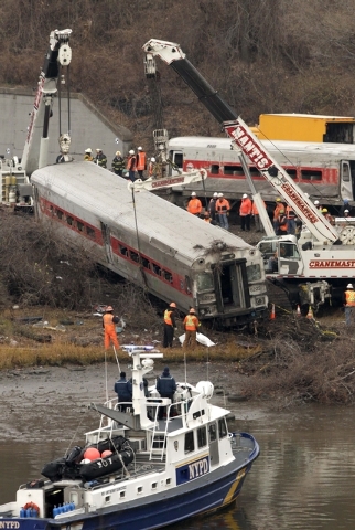 Cranes salvage the last car from from a train derailment in the Bronx section of New York on Monday. Federal authorities began righting the cars Monday morning as they started an exhaustive invest ...