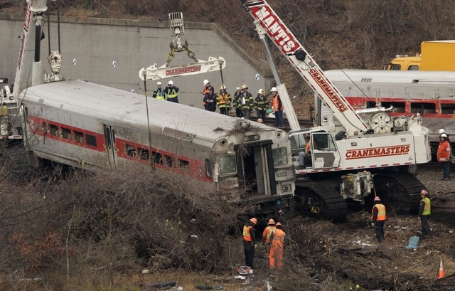Cranes salvage the last car from from a train derailment in the Bronx section of New York on Monday. Federal authorities began righting the cars Monday morning as they started an exhaustive invest ...