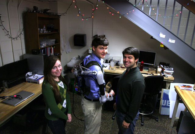 In this Friday, Dec. 6, 2013 photo, Nick McGill, center, wears the Titan Arm, as he poses alongside his student colleagues Elizabeth Beattie, left, and Nick Parrotta at the University of Pennsylva ...