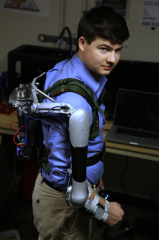 In this Friday, Dec. 6, 2013 photo, Nick McGill wears the Titan Arm as he poses at the University of Pennsylvania in Philadelphia. The robotic device invented by four University of Pennsylvania en ...