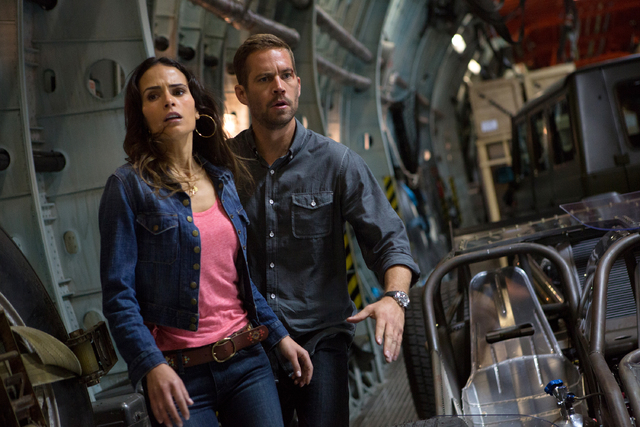 This film publicity image released by Universal Pictures shows Jordana Brewster, left, and Paul Walker in a scene from "Fast & Furious 6." Universal Pictures has delayed the release of F ...