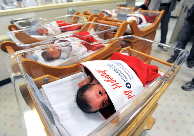 Newborns are bundled up giant stockings at Long Beach Memorial nursery in Long Beach, Calif., on Monday, Dec. 23, 2013. For more than 50 years, babies born between Dec. 21-25 presented to the new  ...