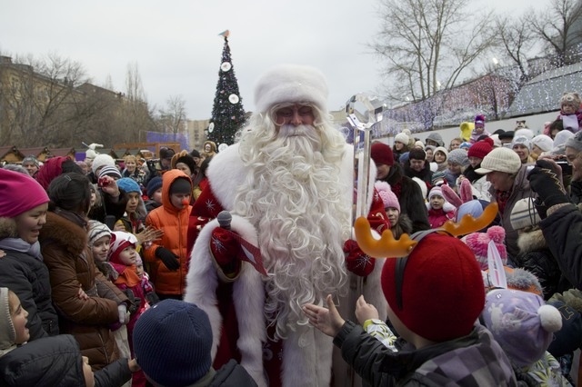 Children surround Russian Ded Moroz (Father Frost), who arrived in Moscow Zoo, as a part of a New Year celebrations, in Moscow, Russia, on Wednesday, Dec. 25, 2013. Russians celebrate Orthodox Chr ...