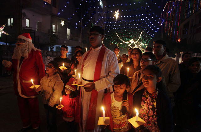Indian Christians hold candles ahead of Christmas in Ahmadabad, India, Tuesday, Dec. 24, 2013. Though Hindus and Muslims comprise the majority of the population in India, Christmas is celebrated w ...