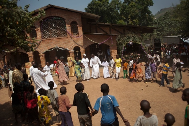 Priests and nuns lead displaced children in a dance during a special Christmas Day mass for children, at a monastery ground serving as a camp for the displaced, in Bangui, Central African Republic ...