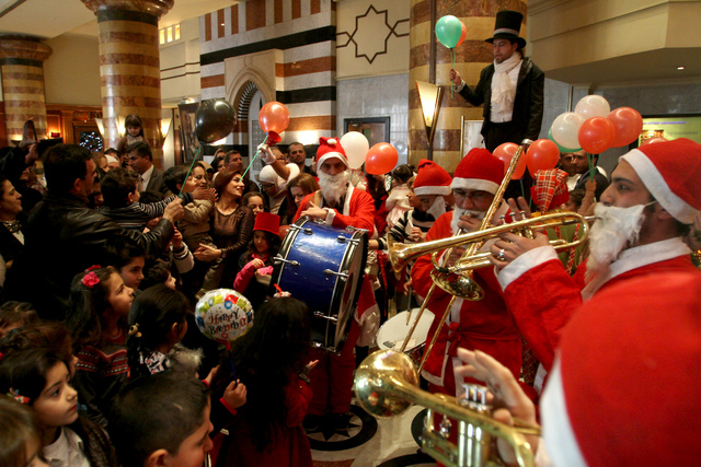 Christians celebrate Christmas during a party held at the Dama Rose hotel in Damascus, Syria on Wednesday, Dec. 25, 2013. Pope Francis' Christmas message, delivered on Wednesday in Italian from th ...