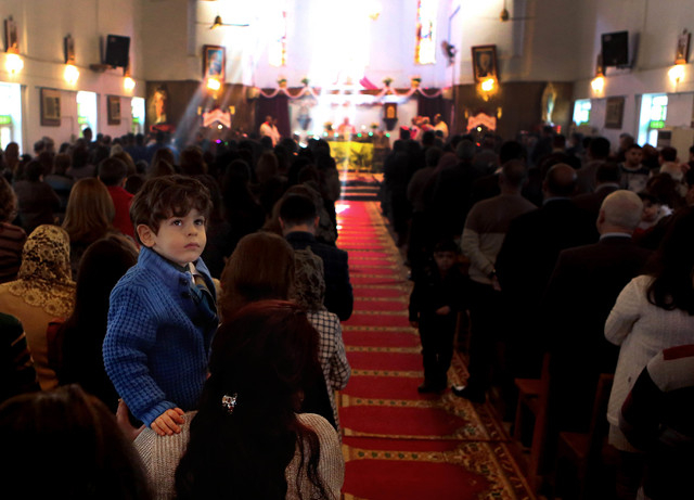 Iraqi Christians attend a Christmas mass at the Mother Teresa Catholic Church in Basra, Iraq's second-largest city, 340 miles (550 kilometers) southeast of Baghdad, Iraq, Wednesday, Dec 25, 2013.  ...