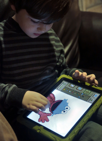 In this Tuesday, Dec. 3, 2013, photo, Marc Cohen, 5, uses a Sesame Street app on his tablet at home in New York. Tablets of all types are expected to rank among the top holiday gifts for children  ...