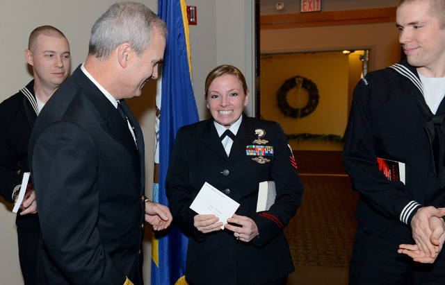 BANGOR, Wash. (Dec. 13, 2013) Navy Counselor 1st Class(SCW/FMF) Sara Dozier, of Naval Submarine Support Center (NSSC) Bangor, receives an envelope from Commander of Submarine Group (CSG) 9 Rear Ad ...