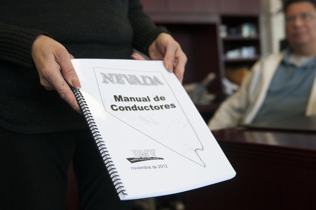 Esperanza Montelongo, owner of Aztec Insurance, shows a DMV driver's manual written in spanish at her office in Las Vegas Saturday, Dec. 28, 2013. Montelongo's office is hosting classes on how to  ...
