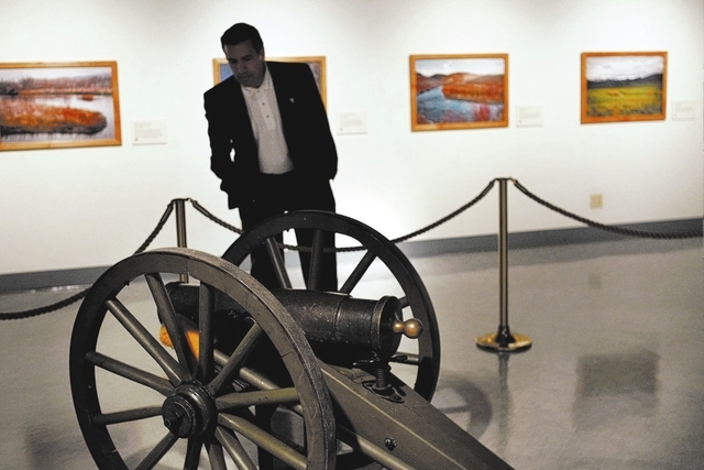Governor Brian Sandoval checks out the original Fremont Cannon exhibit at the Nevada State Museum in Carson City on Oct. 25, 2013. The photos on the wall show locations where John C. Fremont and h ...
