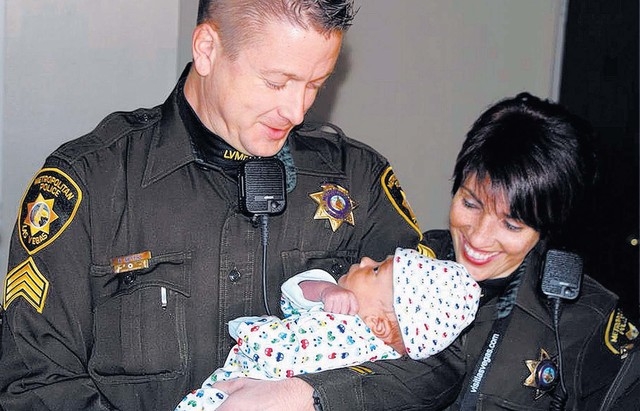 Sgt. Richard Meyers, left, and Officer Lourdes Smith hold the 3 week-old boy whose family Meyers and Smith helped in November. (Courtesy Las Vegas Metro PD)