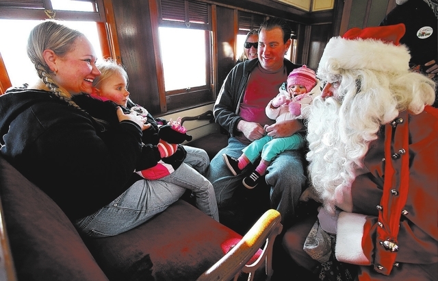 Santa talks with Laura Shuft, Heaven Schuft, 4, David Potts, and Meredith Schuft, 1, on the Santa Train at the Nevada State Railroad Museum in Carson City, Nev., Sunday, Dec. 1, 2013. (Cathleen Al ...