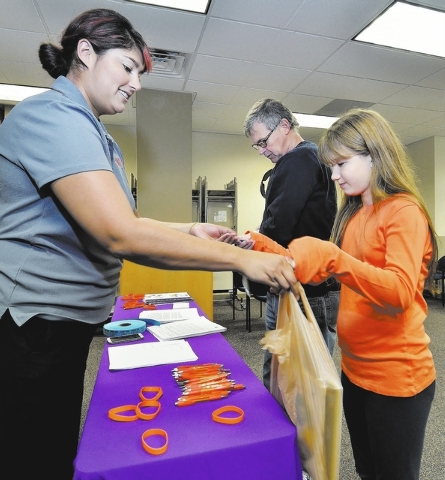 Seventh-grader Christine Kuenzi and her father, Fred, return books to Traci Trevino, local development manager for Nevada Virtual Academy, during a Nov. 18 book exchange at the academy at 8965 S.  ...