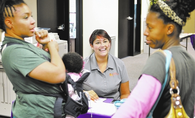 Traci Trevino, local development manager for Nevada Virtual Academy, center, talks with Jacquolyn Lowery, left, and Kimberly Elisarraras during a book exchange on Nov. 18 at the academy, 8965 S. E ...