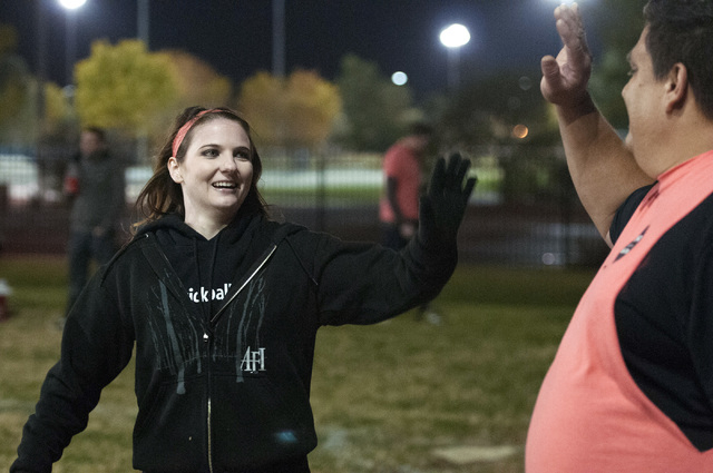 Rachel Rindt and Chad Ovalle, from left, high-five after she scored a run during a kickball game between their team Kick'er & Lick'er and Cream Team at Desert Breeze Park in Las Vegas, Wednesday,  ...