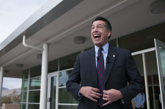 Nevada Gov. Brian Sandoval is shown speaking to to reporters following a ceremony honoring Jeffrey A. Hinton as the Nevada Teacher of the Year at Northwest Career and Technical Academy on Dec. 18, ...