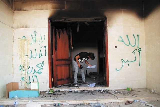 In this Wednesday, Sept. 12, 2012, file photo, a man looks at documents at the U.S. consulate in Benghazi, Libya, after an attack that killed four Americans, including Ambassador Chris Stevens. (A ...